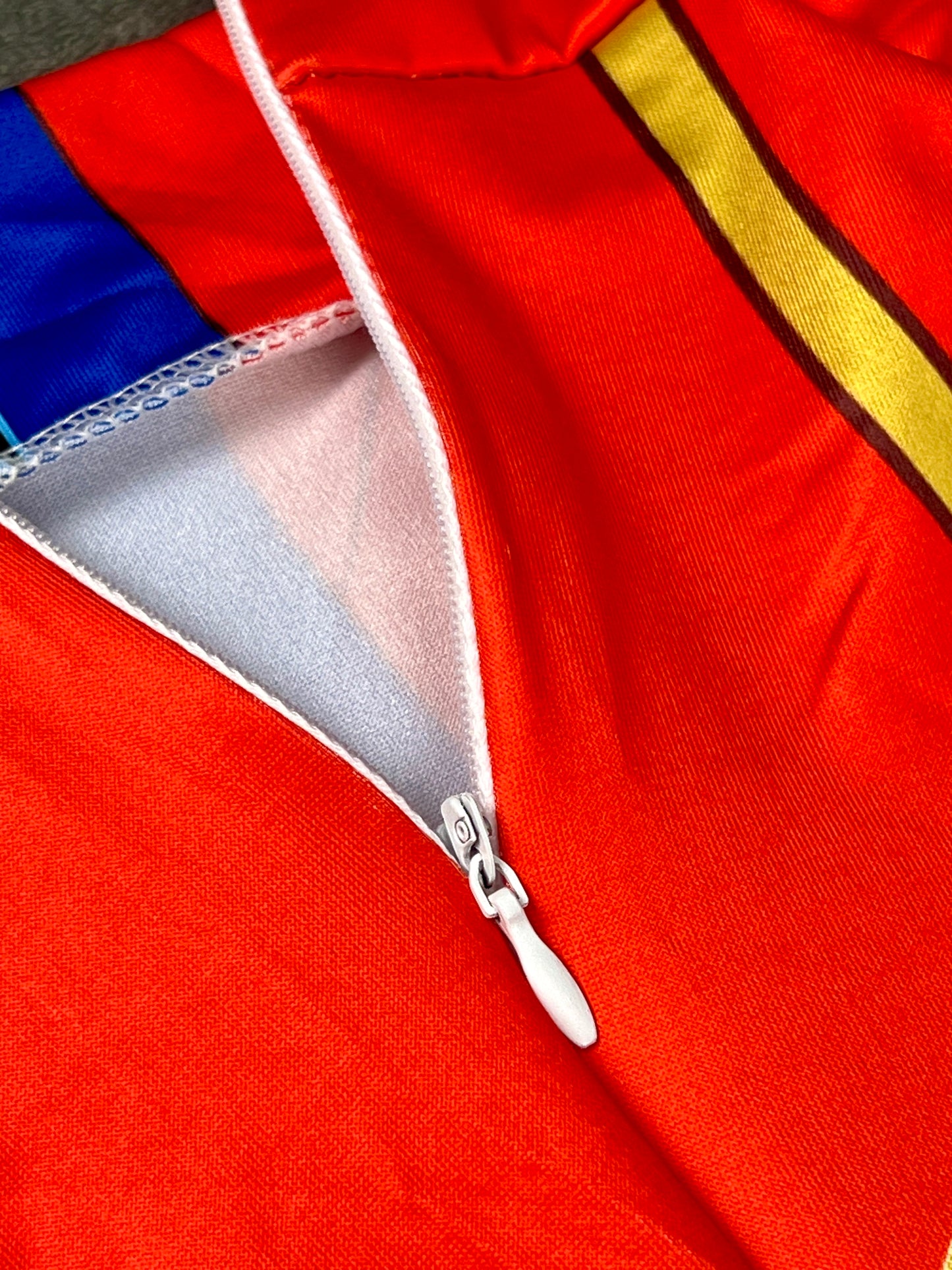 Close-up of a red jacket with a zipper and blue lining.