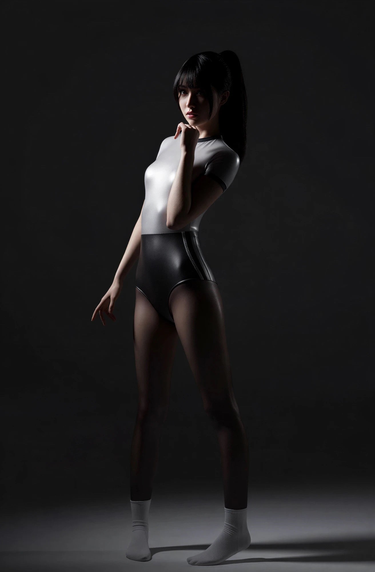 Person wearing a black bodysuit with a white light on a dark background