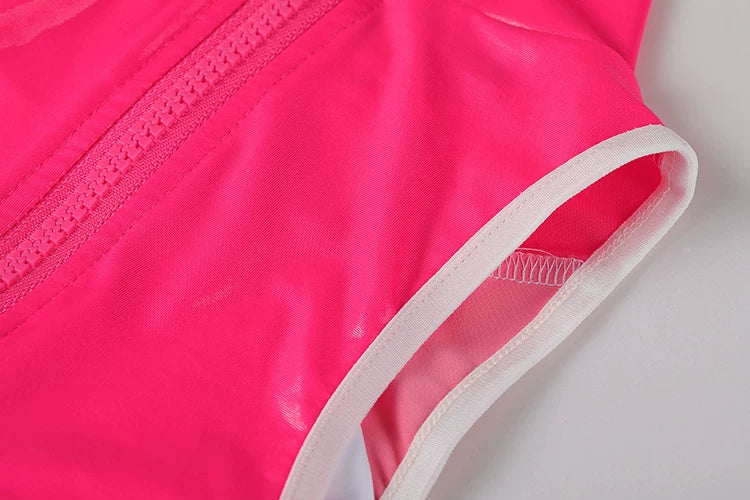 Close-up of a bright pink garment with white trim on a light gray background