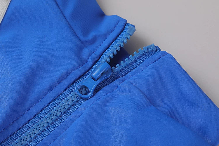 Close-up of a blue zipper on a garment against a neutral background