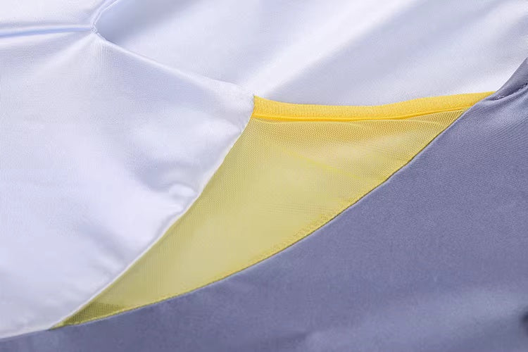 Close-up of a fabric with gray, white, and yellow sections.