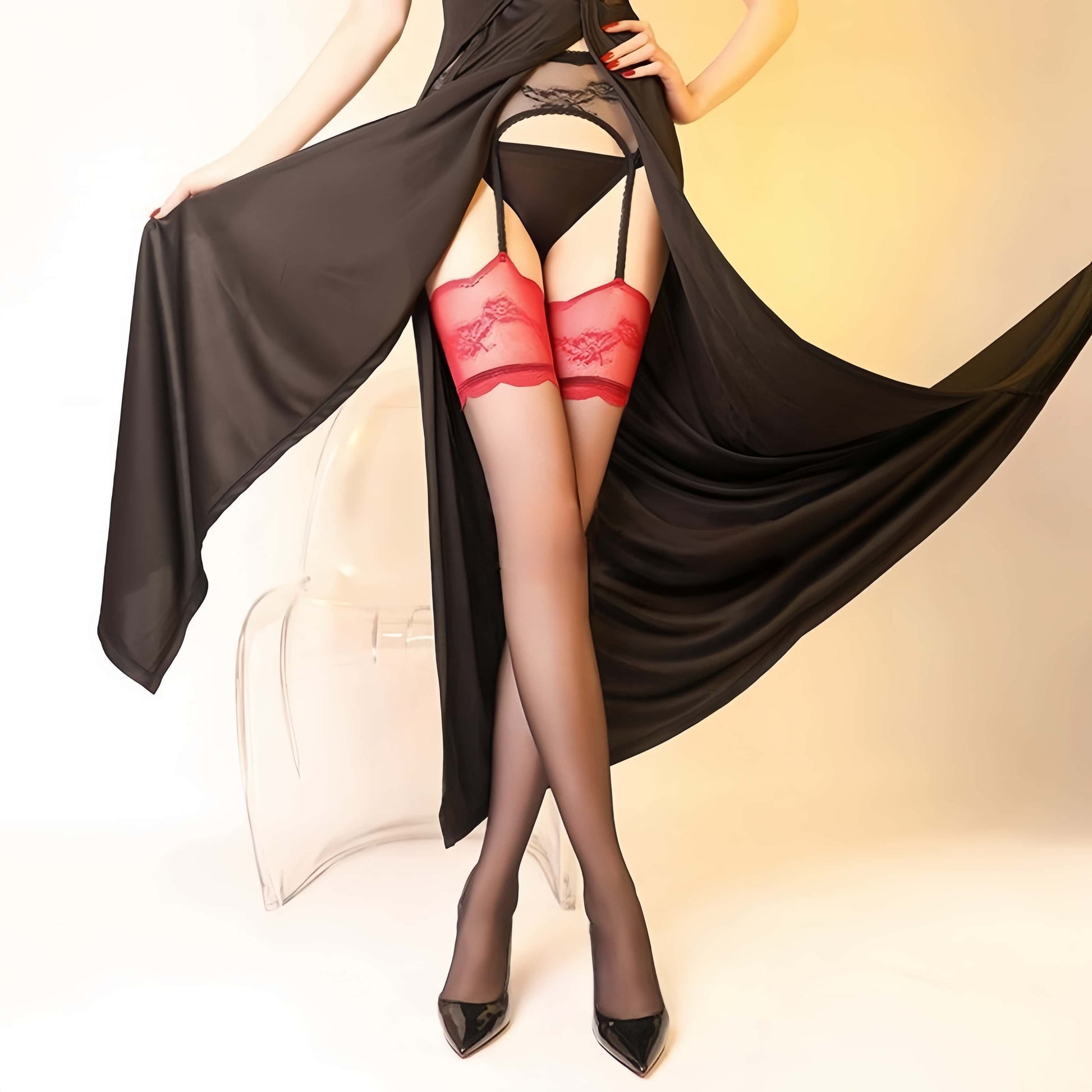 Person wearing red lingerie and black stockings with a draped black fabric background