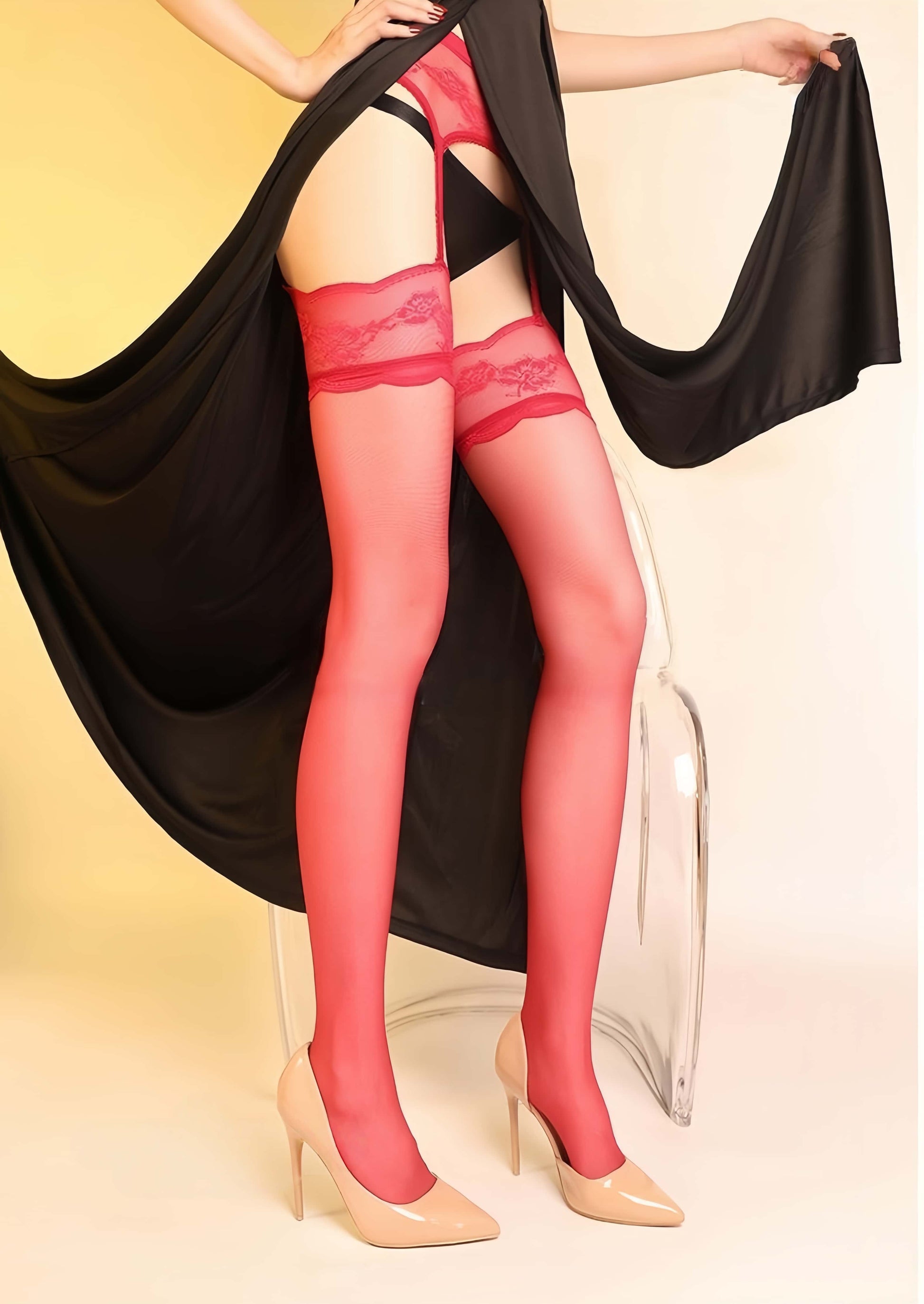 Person wearing red lace stockings with a black fabric draped over them on a gradient background